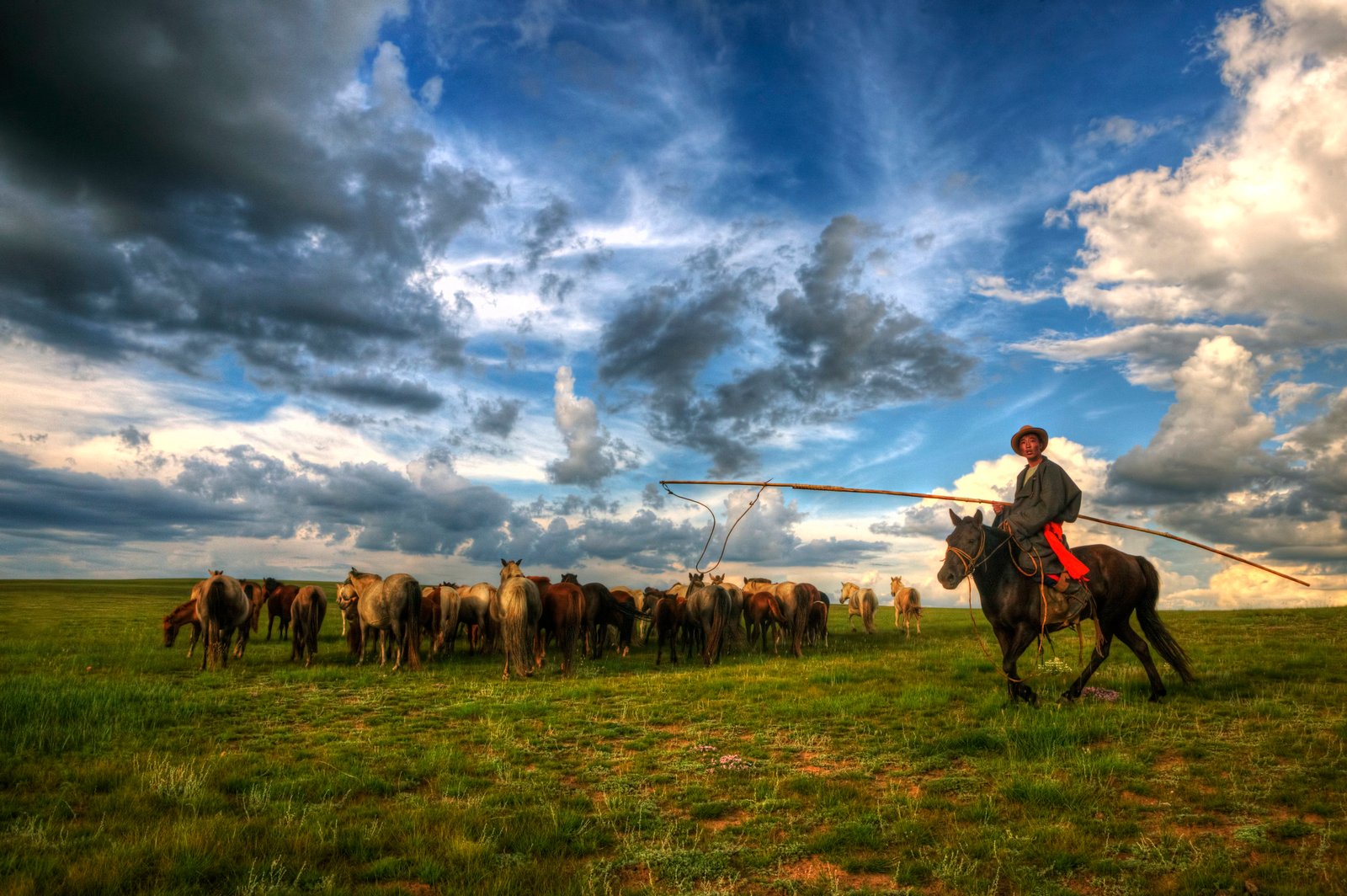 Side-by-side buggy parked beside white gers on the green Central Mongolian steppe
